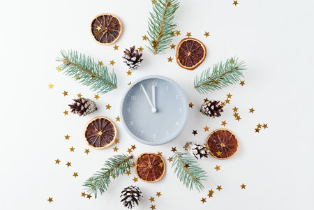 Christmas decorations made of alarm clock, pine cones and fir tree branches on white background, top...