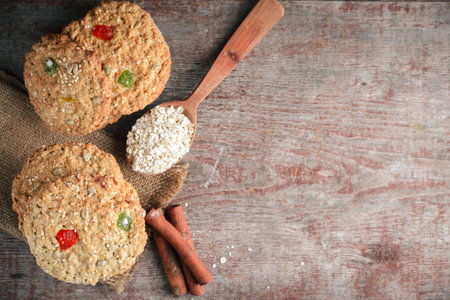 homemade oatmeal cookies, cinnamon sticks and oat flakes on a wooden table. Flat style, top view with copy spaceの写真素材