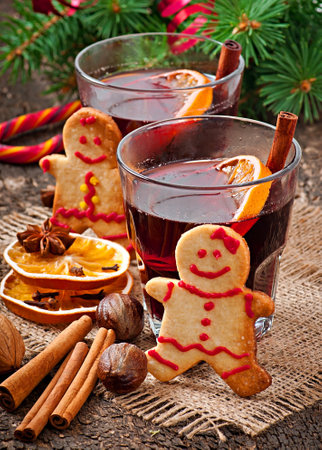 Warming mulled wine, spices and gingerbread cookie on a wooden background in rustic styleの写真素材