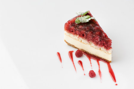 a piece of cake poured with sweet sauce over white backgroundの写真素材