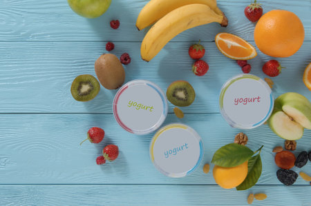 yogurt in a container with tropical fruits on a wooden background, top view. healthy eating conceptの写真素材