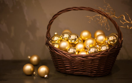 shiny and matt Christmas tree toys golden color in a wicker basket with a branch of the treeの写真素材