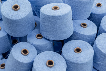a large pile of spools of blue thread. closeup