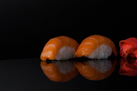 sushi with rice and wasabi on a dark background with reflectionの写真素材