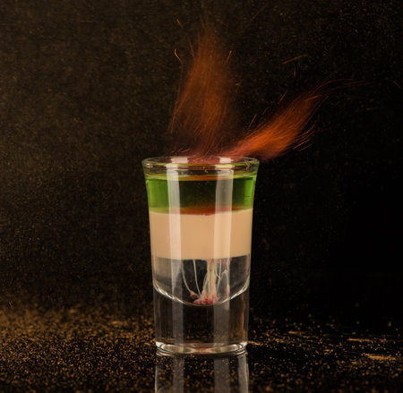 flaming cocktail with cinnamon in a shot glass on a black background, isolatedの写真素材