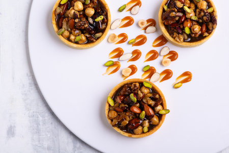 The appetizing tartlets stuffed with hazelnuts walnuts covered with a layer of liquid caramelの写真素材
