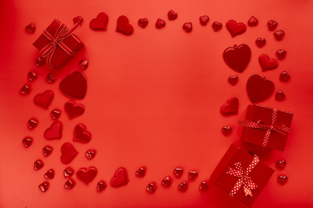 Red hearts and gift boxes on red background. Romantic background for Valentine's day.の写真素材