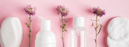 Cosmetic products on pink background. Soap, lotion, and cotton pads. Spa accessories. Wellness concept.の写真素材