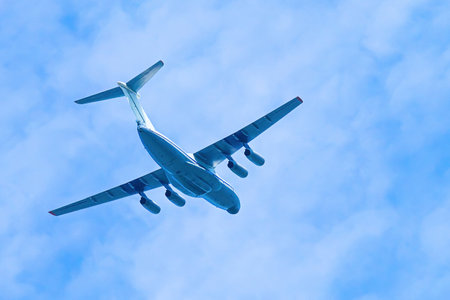 Airplane in blue sky. Air cargo transportation. Plane is flying in the clouds.