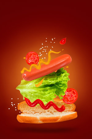 Flying ingredients for a delicious hot dog on a red background. Levitating sausage, tomatoes and lettuce.の写真素材