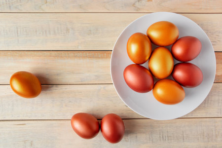 Gold and bronze Easter eggs on a wooden background. Happy spring holiday.の写真素材