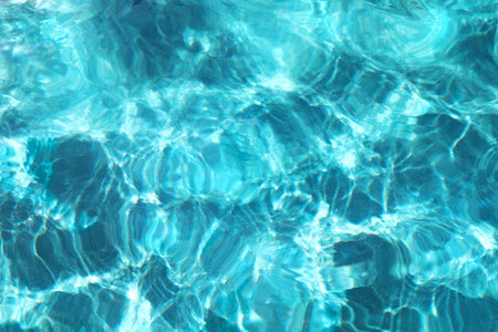 Turquoise blue rippled water surface of swimming pool. Summer vacations resort concept. Background...