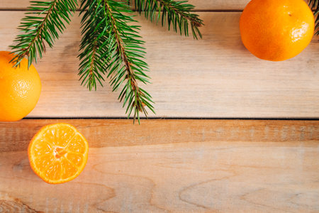 Frame made of fir branches and tangerines on a wooden background. Christmas decor. Place for text.の写真素材