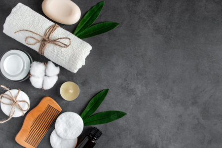 Natural body care cosmetics on concrete background. Spa accessories, towel, hairbrush, essential...