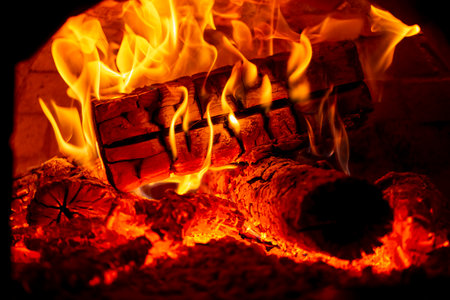 Burning log of wood in a fireplace close-up in a Barbecue.の写真素材