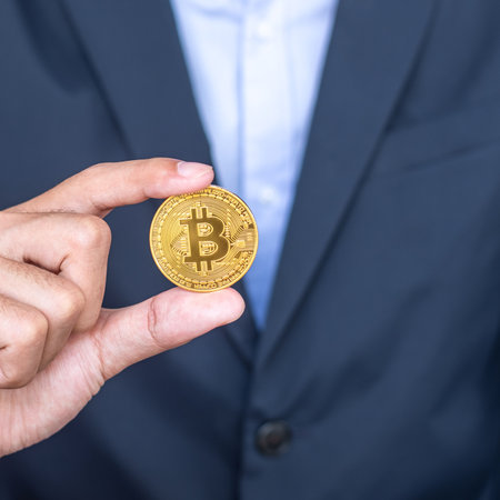 Businessman hand holding golden Bitcoin (BTC) cryptocurrency, Crypto is Digital Money within the blockchain network, is exchanged using technology and online internet exchange. Financial conceptの写真素材