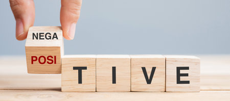 Business man hand holding wooden cube with flip block Negative to Positive word on table background. chance, opportunity, mindset, attitude and Positive thinking conceptsの写真素材