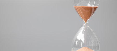 Hourglass on table office with copy space, Sand flowing through the bulb of Sandglass measuring the...