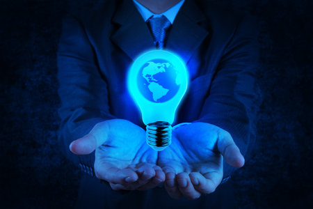 Businessman hand shows Light bulb with planet Earth as conceptの写真素材