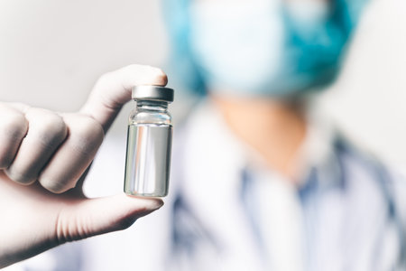 doctor or scientist in laboratory holding a Coronavirus Vaccine in glass bottle. Covid-19 corona virus treatment concept.の写真素材