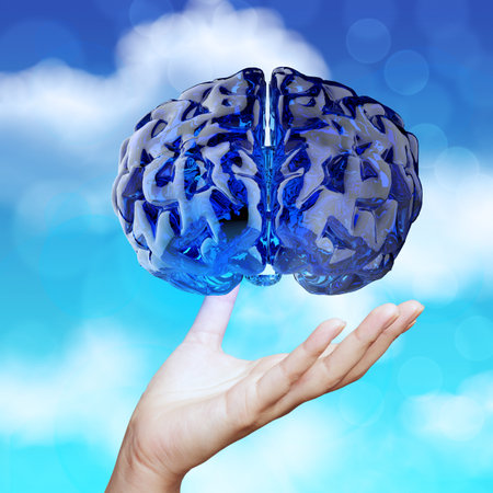 medical doctor hand showing 3d blue glass human brain on nature background as conceptの写真素材