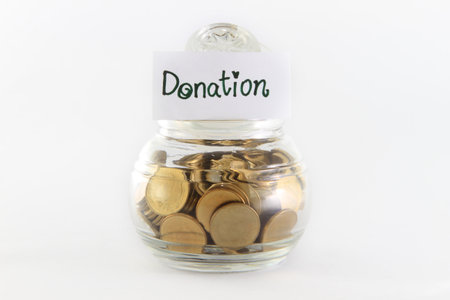 Glass bank for tips with money isolated on whiteの写真素材