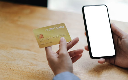 Close up woman holding mobile phone with a white screen and credit card. Online shopping conceptの写真素材