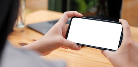 Mockup image woman hand holding texting using black mobile,cell phone with copy space,white blank...
