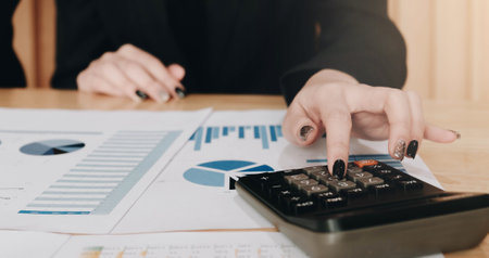 Close up Business woman using calculator and laptop for do math finance on wooden desk in office and...