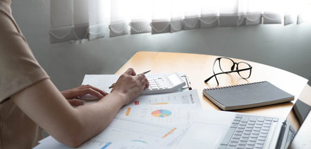 Close up of businesswoman or accountant using calculator to calculate calculate business data,...