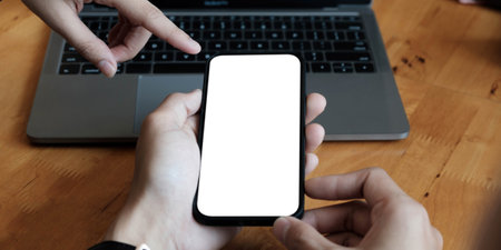 two male hands using smartphone at night on city shopping street, searching or social networks...