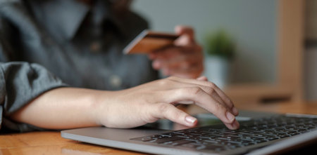 woman hand holding credit card with using laptop for online shopping while making orders at home. business, lifestyle, technology, ecommerce, digital banking and online payment concept.の写真素材