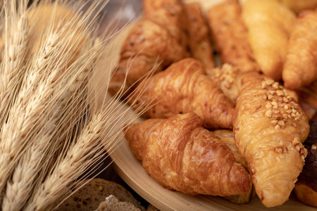 Croissant groups and bakery in wood bolw with wheatgrass on the wooden tableの写真素材