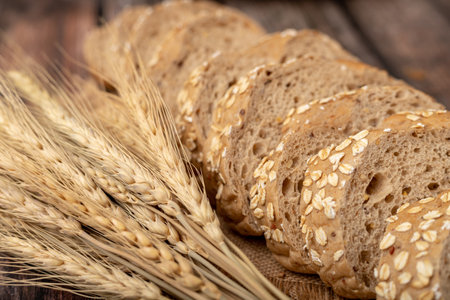 breads sliced and wheatgrass on the sack with a wooden table