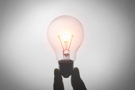 hand holding light bulb isolate on white backgroundの写真素材