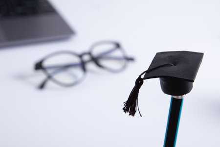 A cap on a pencil on the background of a desktop with office supplies. Online home learning
