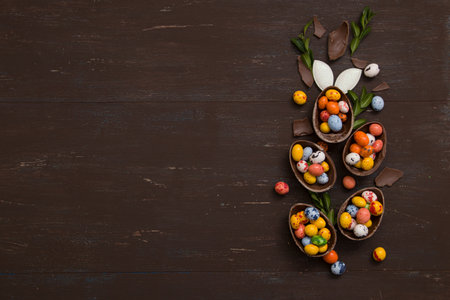 Easter hunt concept background with chocolate Easter eggs on wooden table copy space. View from...