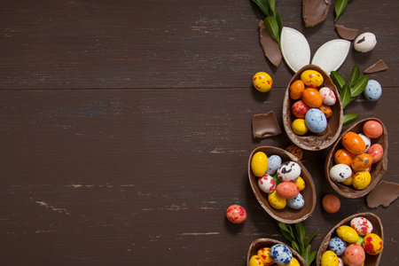 Easter hunt concept background with chocolate eggs and bunny on wooden table copy space. View from above.の写真素材