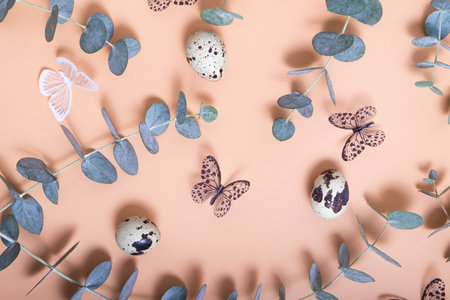 Pattern of Easter eggs, eucalyptus, butterflies and beads. Trendy flat lay composition on color...