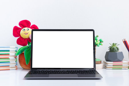 Open laptop mock-up at children's workplace with book and toys. Back to school online learning conceptの写真素材
