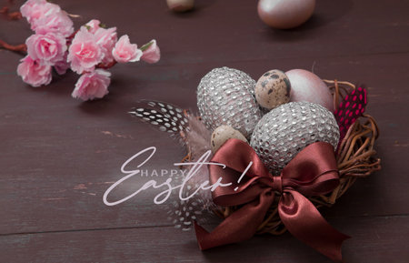 Inscription Happy Easter nest with eggs on a wooden background. Happy Easter greeting card with creative easter eggs and blossom flowersの写真素材