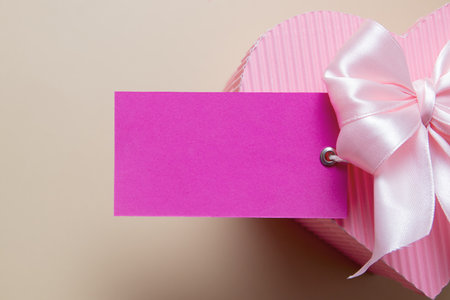 Blank card with pink heart shaped gift box and bowの写真素材