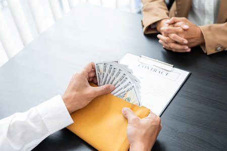 two hands passing bills making agreement to initiate the new business.の写真素材