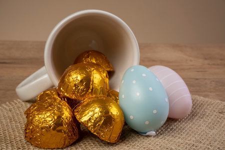 chocolate truffles wrapped in golden foil next to Easter ornaments.の写真素材