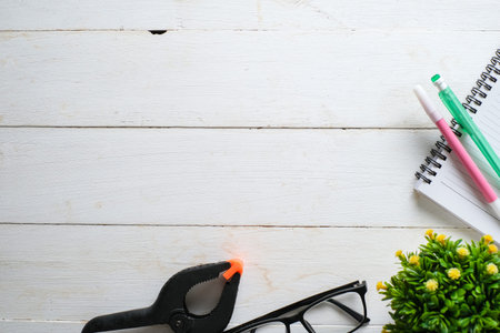 White wooden table with note book, eyeglasses, pen, decorative plants. Top view with copy space, flat lay.の写真素材