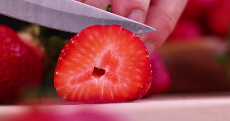 Cut into pieces ripe red strawberries, red strawberries are divided into slices for dessertの写真素材