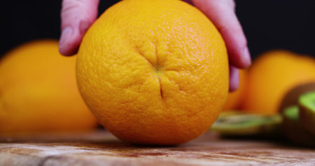 cut an orange into pieces on a wooden chopping board, cooking food and desserts from ripe citrus orangeの写真素材
