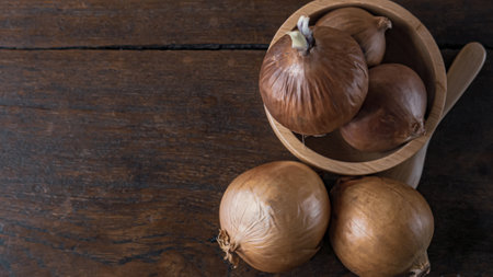 The onion in wood bowl  on wood table for food content.