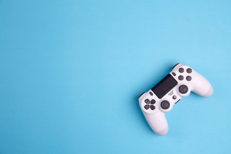 Joystick gaming controller isolated on blue background , Video game console developed Interactive...