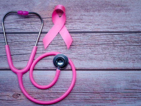 Pink ribbon and stethoscope on wooden table vintage style. Symbol of breast cancer, health care conceptの写真素材